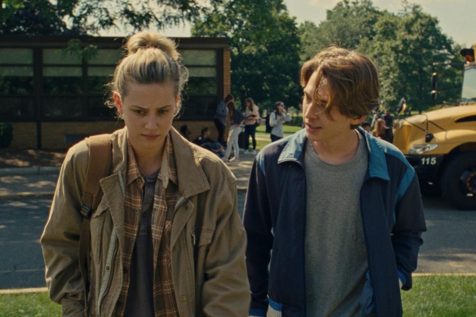 Lili Reinhart and Austin Abrams walking away from a school bus