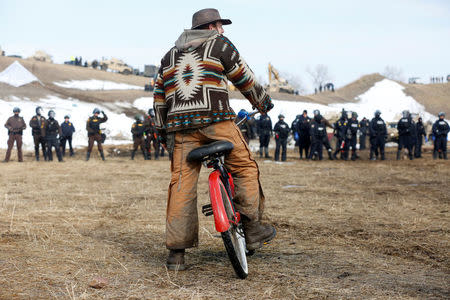 Jasper Spillman, 30, of Lawrence, Kansas, watches law enforcement officers advance into the main opposition camp against the Dakota Access oil pipeline near Cannon Ball, North Dakota, U.S., February 23, 2017. REUTERS/Terray Sylvester