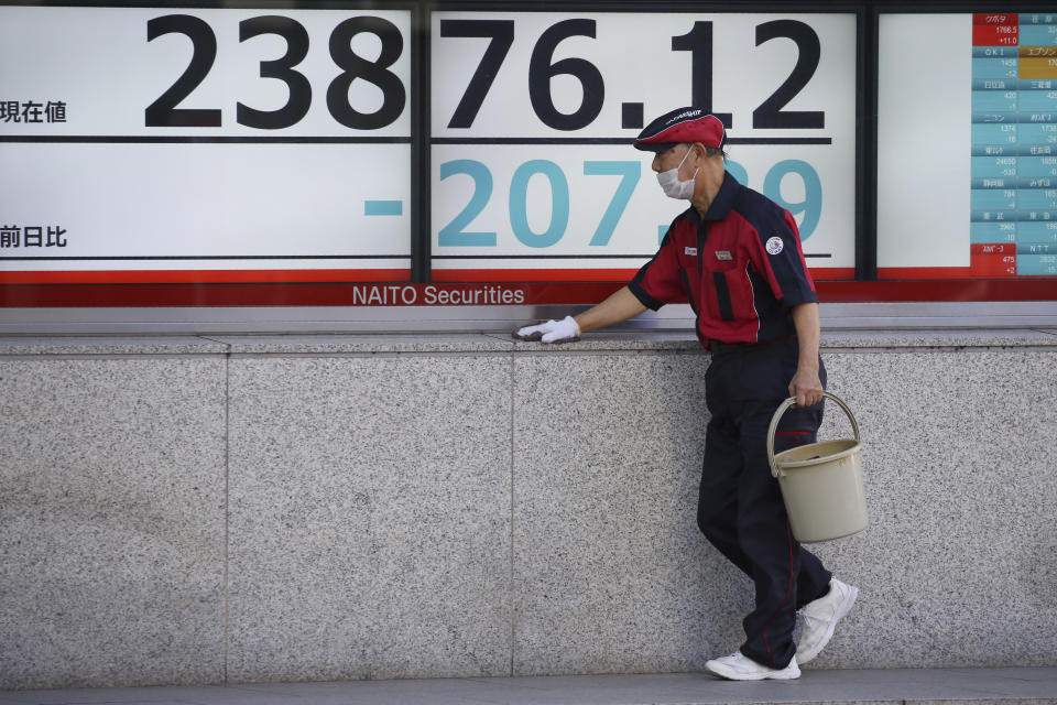 A worker cleans up an electronic stock board of a securities firm in Tokyo, Tuesday, Jan. 21, 2020. Asian stock markets have tumbled as concern about the impact of a Chinese disease outbreak on tourism and regional economies grows. (AP Photo/Koji Sasahara)