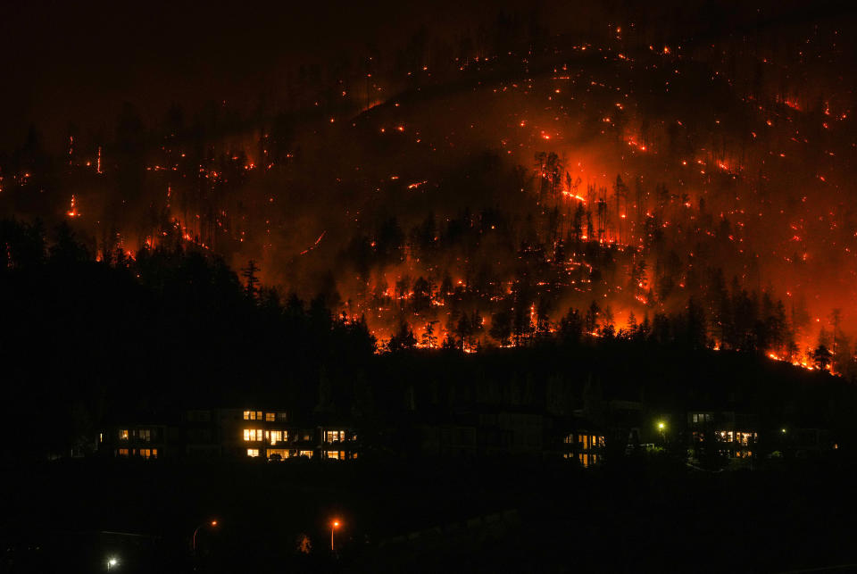 The McDougall Creek wildfire burns on the mountainside above houses in West Kelowna, B.C., on Friday, August 18, 2023. THE CANADIAN PRESS/Darryl Dyck