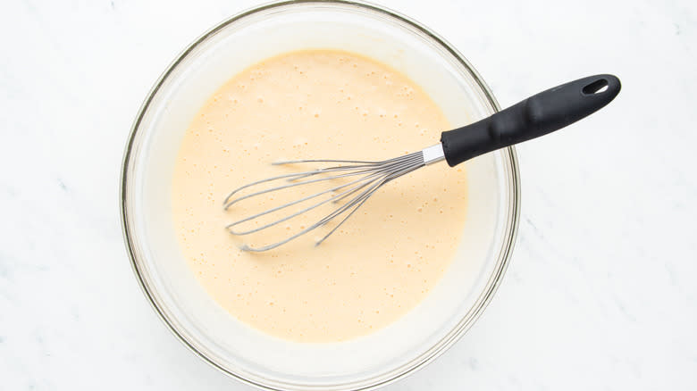 Waffle batter whisked in bowl