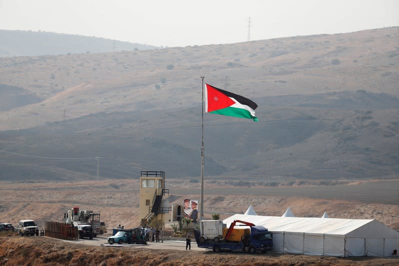 A Jordanian national flag is lifted near a tent at the "Island of Peace" in an area known as Naharayim in Hebrew and Baquora in Arabic, on the Jordanian side of the border with Israel, as seen from the Israeli side