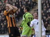 Hull City's James Chester (L) reacts after scoring an own goal as Manchester United's Wayne Rooney celebrates during their English Premier League soccer match at the KC Stadium in Hull, northern England December 26, 2013. REUTERS/Nigel Roddis