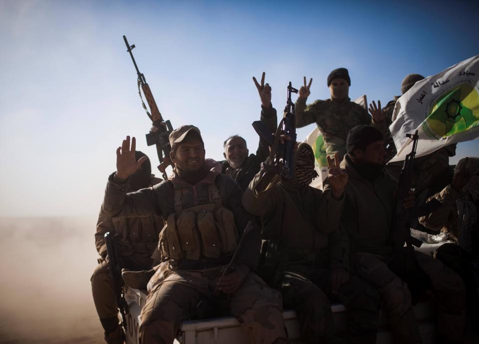 Soldiers of the Hashd al Shaabi (Popular Mobilisation Units) wave the victory sign onboard a pickup truck: AFP/Getty