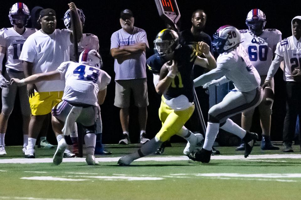 Brock Glenn runs past Bartlett defenders on Sept. 9.