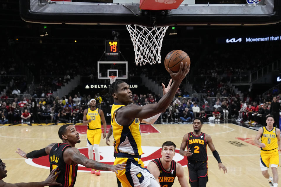 Indiana Pacers guard Bennedict Mathurin scores against Atlanta Hawks guards Dejounte Murray (5) and Bogdan Bogdanovic during the first half of an NBA basketball game Friday, Jan. 12, 2024, in Atlanta. (AP Photo/John Bazemore)