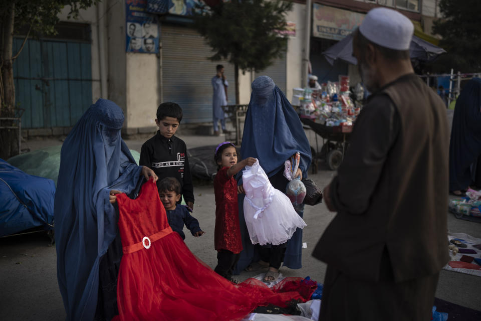 Afghan women and a girl shop for dresses at a local market in Kabul, Afghanistan, Friday, Sept. 10, 2021. (AP Photo/Felipe Dana)