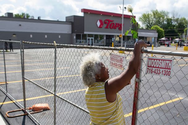 PHOTO: Cariol Horne places a rose on the fence outside the Tops Friendly Market, July 14, 2022, in Buffalo, N.Y.  (Joshua Bessex/AP)