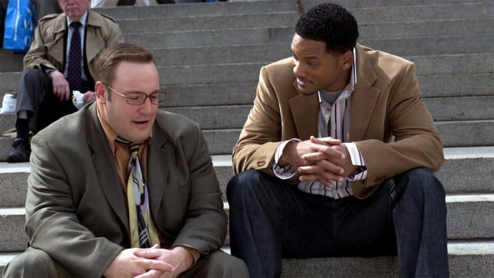 Two men sit on steps next to each other in Hitch.
