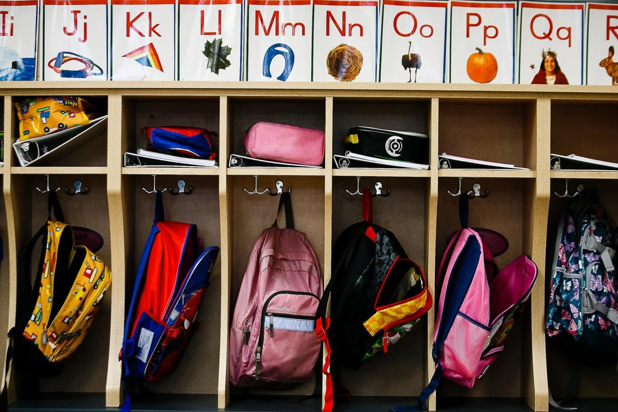 Backpacks hang in cubbies on the first day of school.