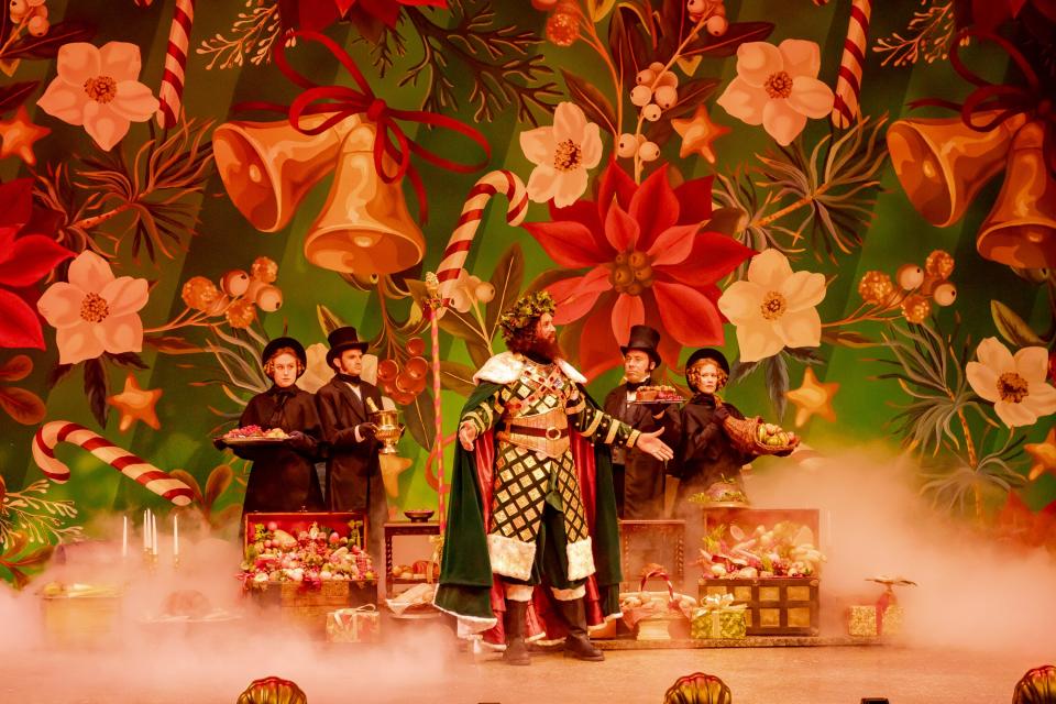 In this scene from the Playhouse in the Park’s new production of “A Christmas Carol,” The Ghost of Christmas Present (Kenneth Early, center) appears to Ebenezer Scrooge, accompanied by four characters bearing scrumptious treats and delicacies. The characters are (background, left to right) Dina Monk, Aaron Schilling, Rory Sheridan and Tess Talbot.