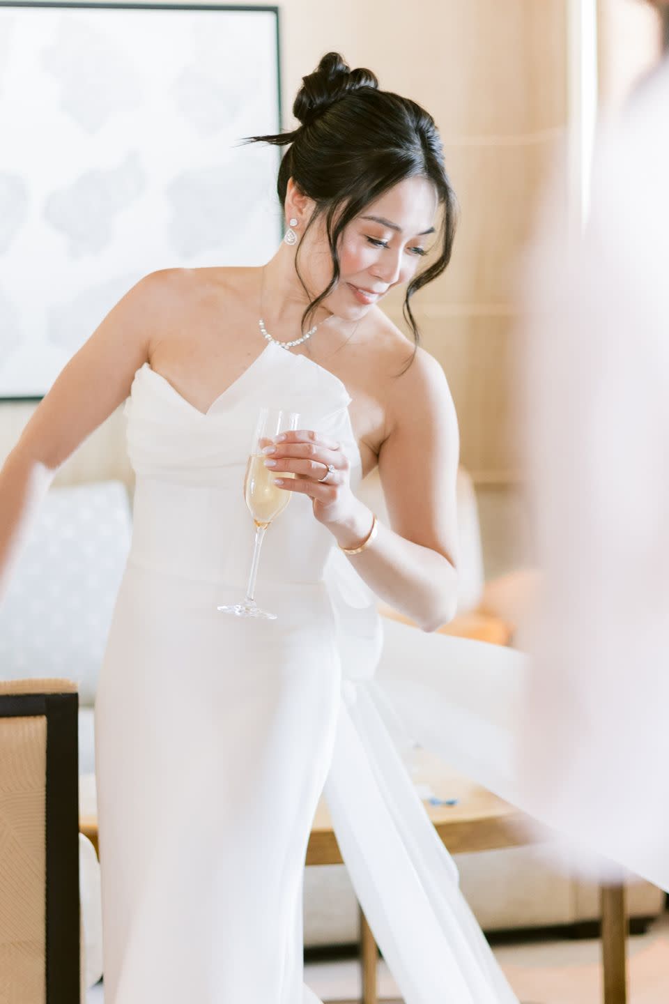 a person in a white dress holding a glass of wine