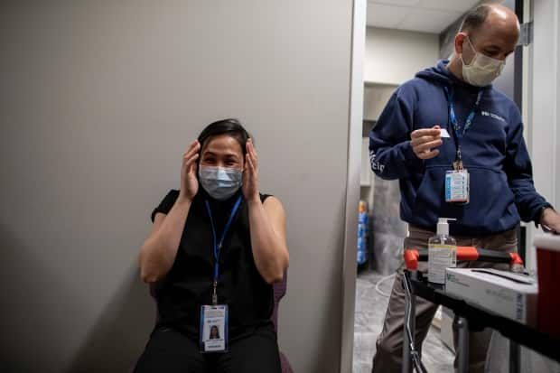 Nurse Catherine Serrano, who is 32 weeks pregnant, gets a dose of the Pfizer-BioNTech COVID-19 vaccine from Ruben Rodriguez at The Church Of Pentecost Canada in northwest Toronto.