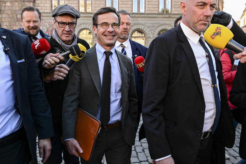 The Moderate party leader Ulf Kristersson, center, is surrounded by reporters on his way to meet met with Andreas Norlen, the speaker of the 349-seat Swedish parliament, to submit a report on the formation of the new Swedish government, in Stockholm, Wednesday, Oct. 12, 2022. (Jonas Ekströmer/TT News Agency via AP)