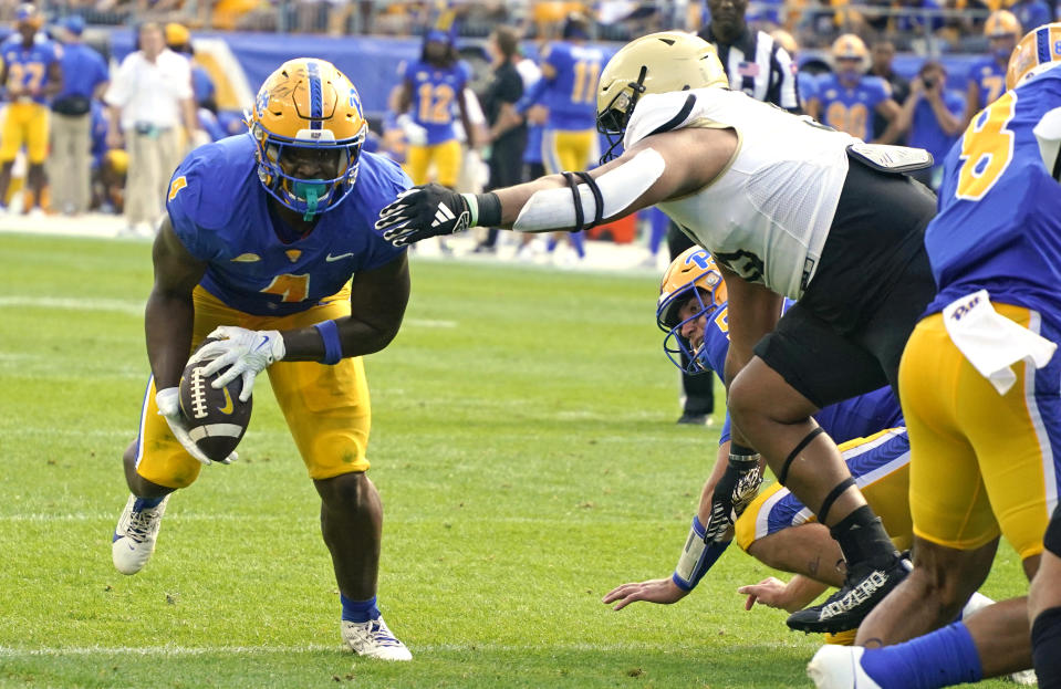 Pittsburgh running back Daniel Carter, left, recovers a fumble by quarterback Phil Jurkovec, right rear, and carries it into the end zone for a touchdown during the first half of an NCAA college football game against Wofford in Pittsburgh Saturday, Sept. 2, 2023. (AP Photo/Gene J. Puskar)