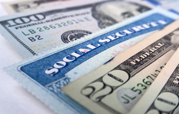 A Social Security card inserted between $20 and $100 bills