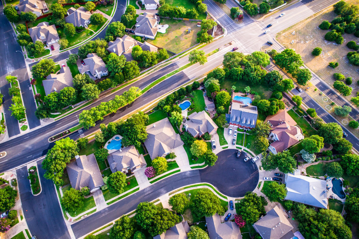 Vast Homes and Thousands of Houses Modern Suburb Development - aerial drone view looking straight down from above Intersection at Road and Urban Modern Suburb houses and homes colorful rooftops