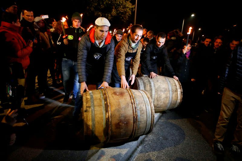 FILE PHOTO: People roll barrels of Beaujolais Nouveau wine for the official launch of the 2019 vintage in Lyon