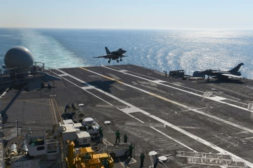 A French Navy Rafale jet lands on the deck of the USS George H.W. Bush aircraft carrier, while France's only carrier undergoes renovations