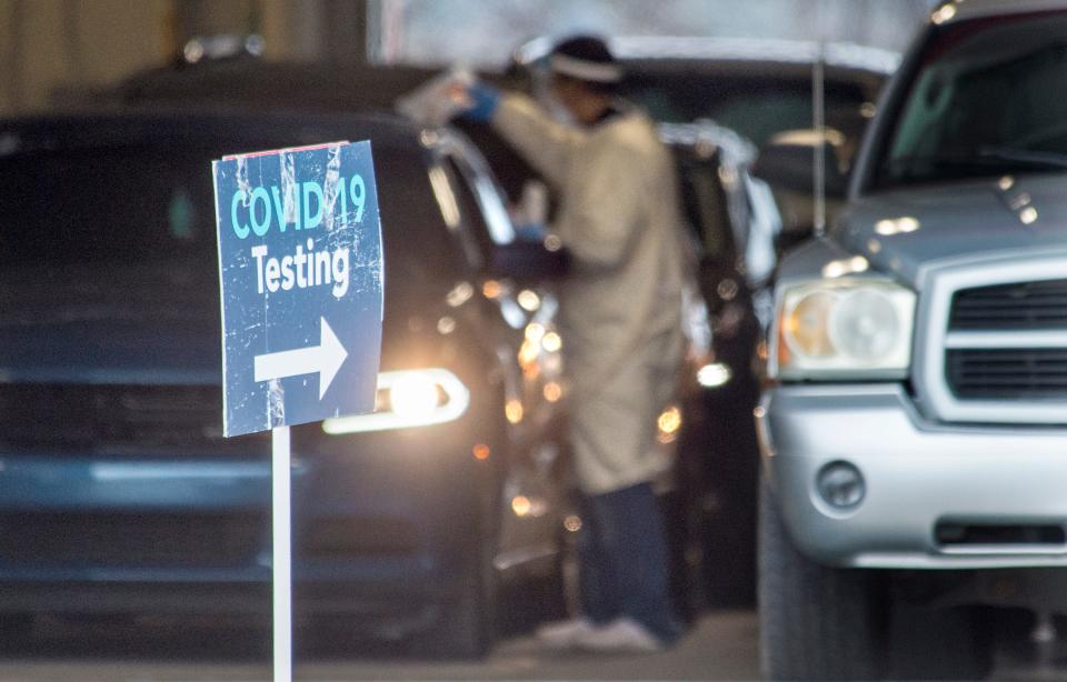 FILE - Medical personnel walk between cars as they collect samples from motorists for COVID-19 testing at Augusta University Health's testing site in Augusta on February 1, 2021. This testing site has since closed down, but tests are still available across Georgia.