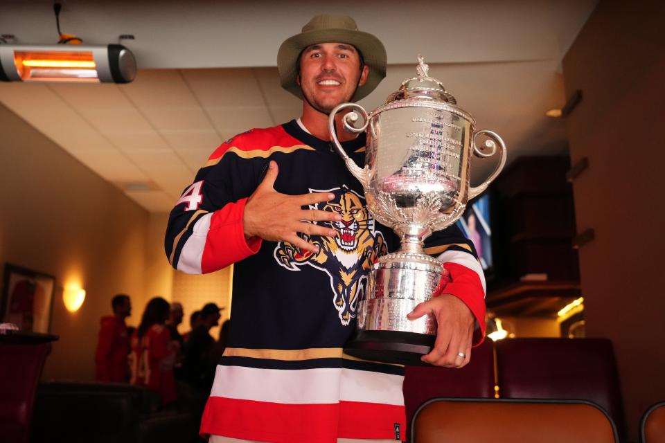 Pro golfer Brooks Koepka poses with the Wanamaker Trophy while attending game three of the Eastern Conference Finals of the 2023 Stanley Cup Playoffs between the Florida Panthers and the Carolina Hurricanes at FLA Live Arena.