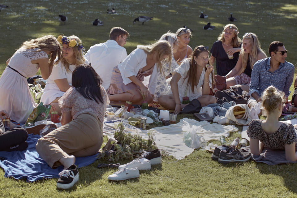 FILE - In this Friday June 19, 2020 file photo people picnic during the annual Midsummer celebrations in Stockholm, Sweden. Sweden's relatively low-key approach to coronavirus lockdowns captured the world's attention when the pandemic first hit Europe. But it also had a per capita death rate much higher than other Nordic countries. Now, as infection numbers surge in much of Europe, Sweden has some of the lowest numbers of new cases and there are only 14 people being treated for the virus in intensive care in the country of 10 million.(AP Photo/Andres Kudacki, File)