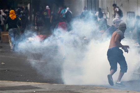 Anti-government protesters run from tear gas during a protest against Nicolas Maduro's government in Caracas March 13, 2014. REUTERS/Carlos Garcia Rawlins