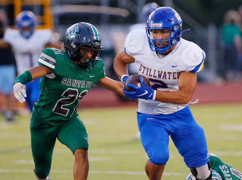 Stillwater's Gabe Brown (2) takes off after catching a pass with Edmond Santa Fe's Tyler Lewis (21) in pursuit Sept. 3 in Edmond.