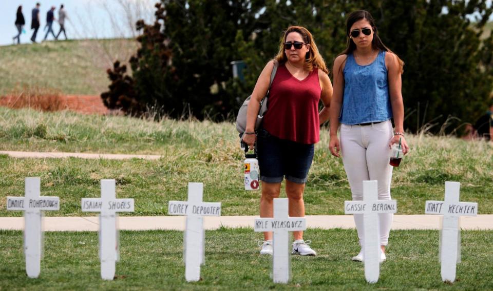 PHOTO: Michelle Aguayo of Morrison and her daughter, Ciara Shannon stop by an ad hoc display of crosses with the names of students killed in the 1999 attack on Columbine High School at the Columbine Memorial, April 20, 2019, in Littleton, Colorado.  (Joe Mahoney/Getty Images)
