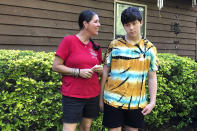 Molly Ball talks to her son Henry about plans to send him back to in-person classes this fall, as they stand outside their house in Woodstock, Ga., Thursday, July 23, 2020. Ball says she thinks Henry and his brother William need the structure and routine of in-person classes, but has regrets about not keeping them home to learn virtually amid the COVID-19 pandemic. Cherokee County, near Atlanta, is one of many districts nationwide that gave parents a choice between in-person and all-online classes this fall. (AP Photo/Jeff Amy)