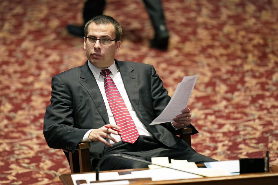 State Sen. Roby Smith, R-Davenport, works at his desk in the Iowa Senate chamber, Wednesday, Feb. 24, 2021, at the Statehouse in Des Moines, Iowa. Iowa Republicans were moving swiftly Wednesday to sharply limit early voting in the state, months after a general election overseen by a Republican secretary of state resulted in record turnout and overwhelming victories by GOP candidates. (AP Photo/Charlie Neibergall)