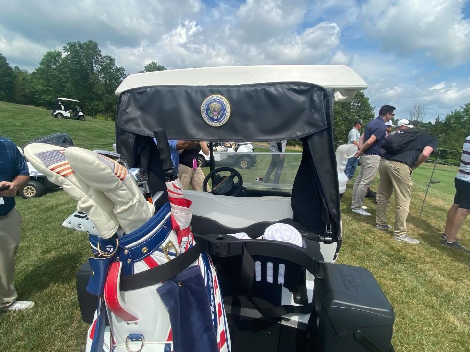 The back of Trump's golf cart, featuring the presidential seal and his red, white, and blue golf bag.