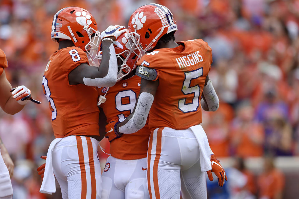 Clemson's Travis Etienne, center, celebrates a touchdown with teammates Tee Higgins, right, and Justyn Ross during the first half of an NCAA college football game against Florida State Saturday, Oct. 12, 2019, in Clemson, S.C. (AP Photo/Richard Shiro)