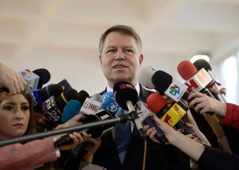 Romanian President Klaus Iohannis speaks to the press after voting at a polling station in Bucharest during parliamentary elections on December 11, 2016