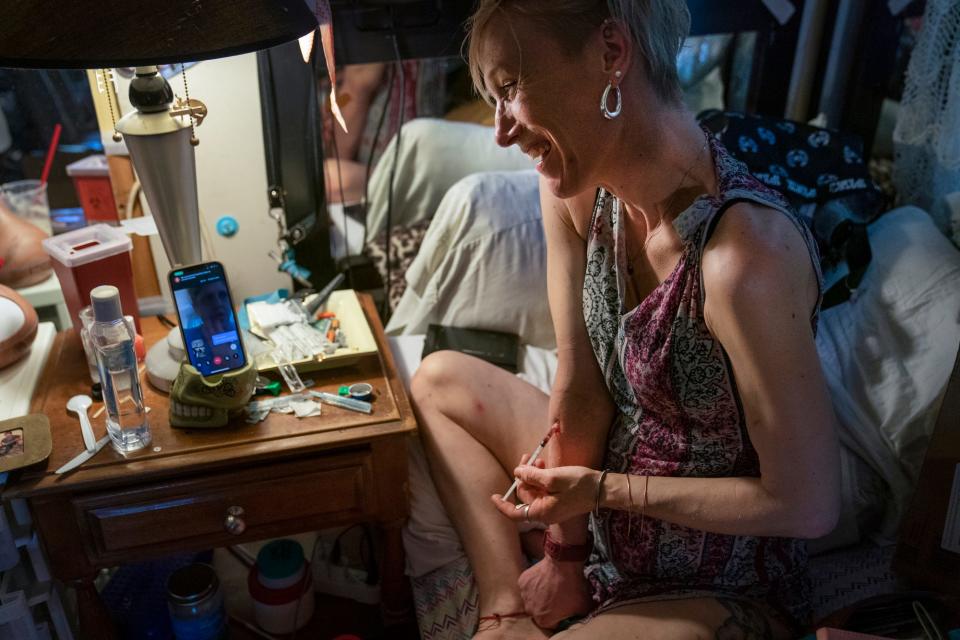 Amanda speaks to a friend on a video phone call as she casually shoots up heroin in her Detroit bungalow back bedroom on Friday, June 3, 2022.