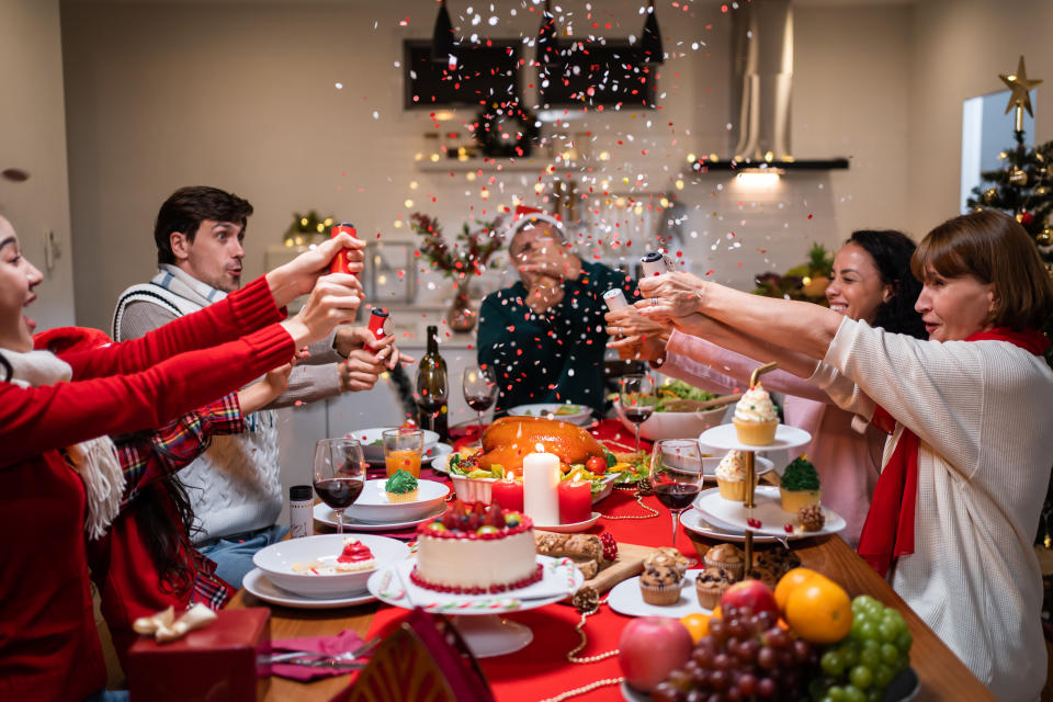 family at christmas round table pulling crackers