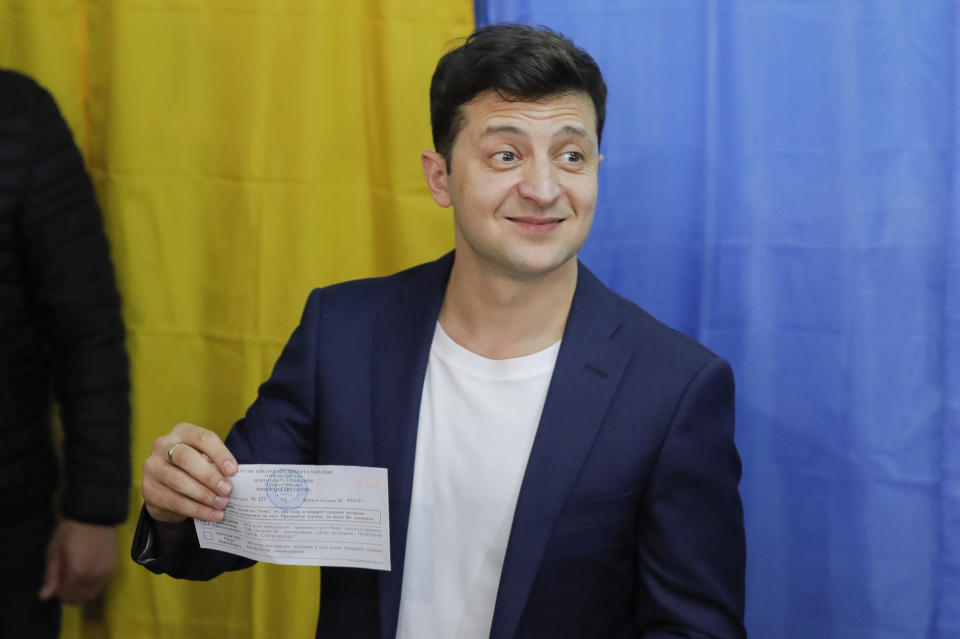 Ukrainian comedian and presidential candidate Volodymyr Zelenskiy shows his ballot before casting his ballot at a polling station, during the second round of presidential elections in Kiev, Ukraine, Sunday, April 21, 2019. Top issues in the election have been corruption, the economy and how to end the conflict with Russia-backed rebels in eastern Ukraine. (AP Photo/Vadim Ghirda)