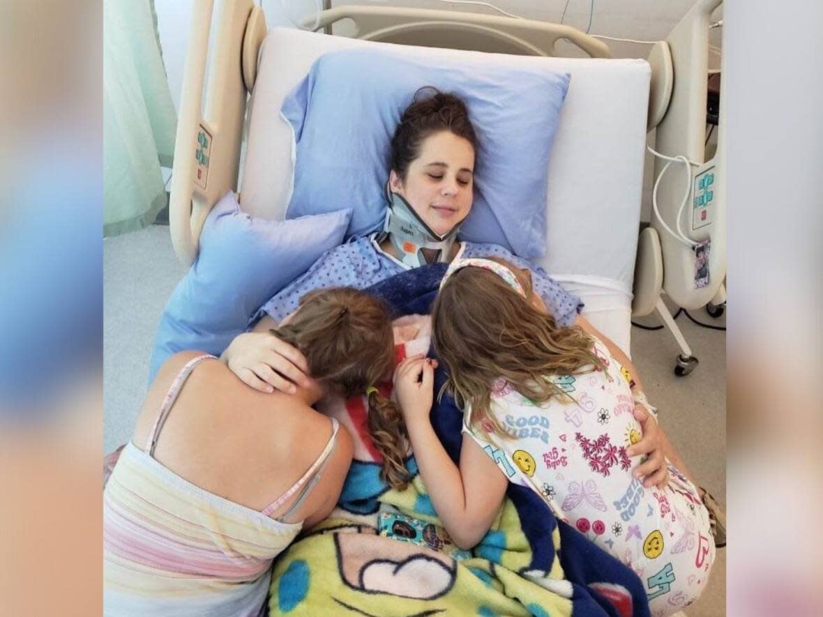 Rachel Stanford gets some family hugs in hospital as she recovers from a broken neck and other injuries. (Submitted by Ben Stanford - image credit)