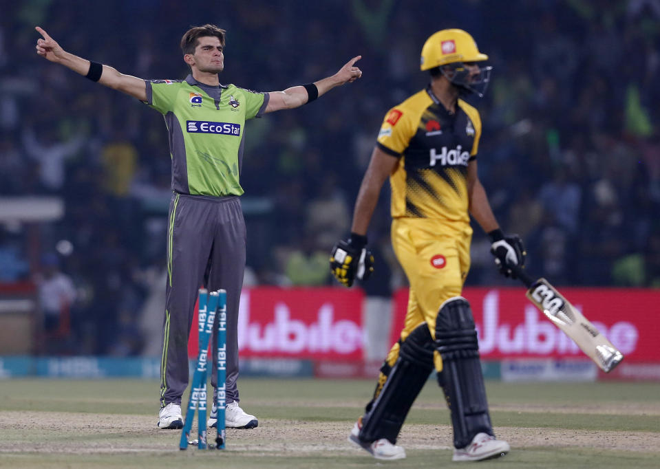 Lahore Qalandars pacer Shaheen Shah Afridi, left, celebrates after the dismissal of Peshawar Zalmi batsman Whahab Riaz during a Pakistan Super League T20 cricket match, in Lahore, Pakistan, Tuesday, March 10, 2020. (AP Photo/K.M. Chaudary)