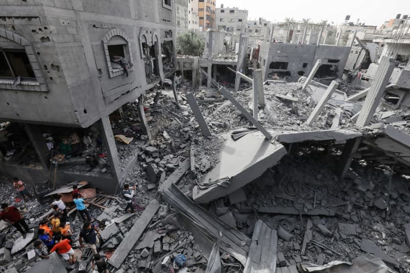 Palestinians inspect damages following an Israeli air strike on Al Maghazi refugee camp, in the central Gaza Strip. Omar Naaman/dpa