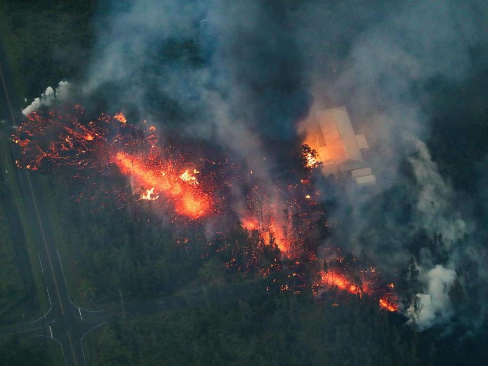 A 2,000 foot long fissure erupts within the Leilani Estates subdivision, on the east rift zone of the Kilauea volcano, igniting a home, and creating a black plume of smoke (EPA/BRUCE OMORI / PARADISE HELICOPTERS)