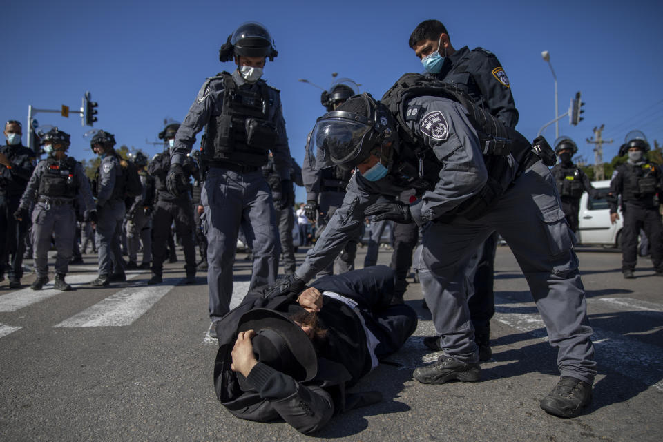 File - In this Sunday, Jan. 24, 2021 file photo, Israeli police officers clash with ultra-Orthodox Jews in Ashdod, Israel. Ultra-Orthodox demonstrators clashed with Israeli police officers dispatched to close schools in Jerusalem and Ashdod that had opened in violation of coronavirus lockdown rules, on Sunday. (AP Photo/Oded Balilty, File)