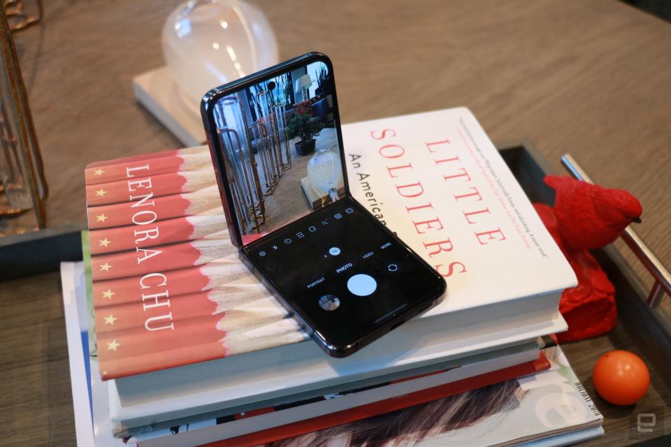 The Samsung Galaxy Z Flip 5 folded at a 90-degree angle and sitting on a stack of books with the camera app showing.