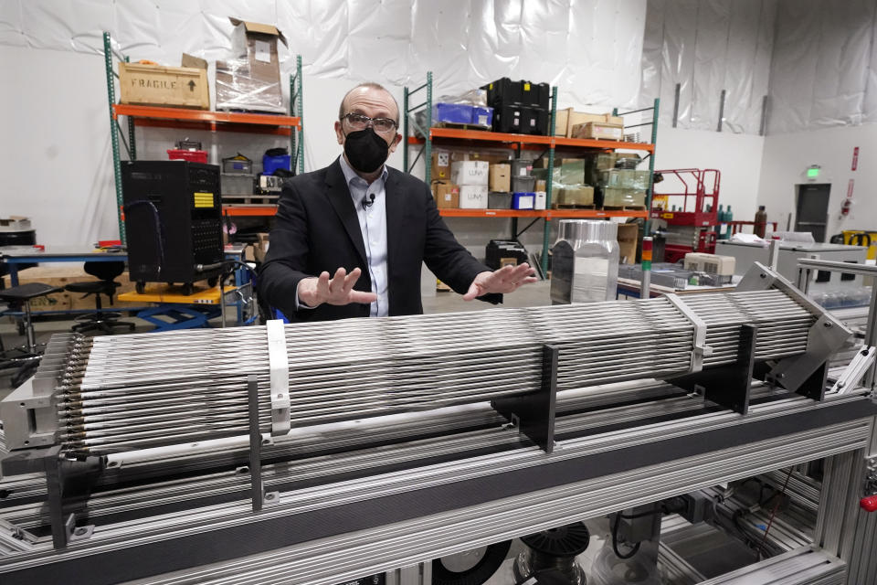 Chris Levesque, president and CEO of TerraPower, a company developing and building small nuclear reactors, displays a fuel assembly model, Thursday, Jan. 13, 2022, in Everett, Wash. The 5-foot model is about one-third actual length and would be vertical when in use, rather than horizontal. By cooling the reactor with liquid sodium, a metal that solidifies at well above room temperature, TerraPower says its relatively small, 345-megawatt plant will be safe and less expensive than conventional, water-cooled nuclear plants. (AP Photo/Elaine Thompson)