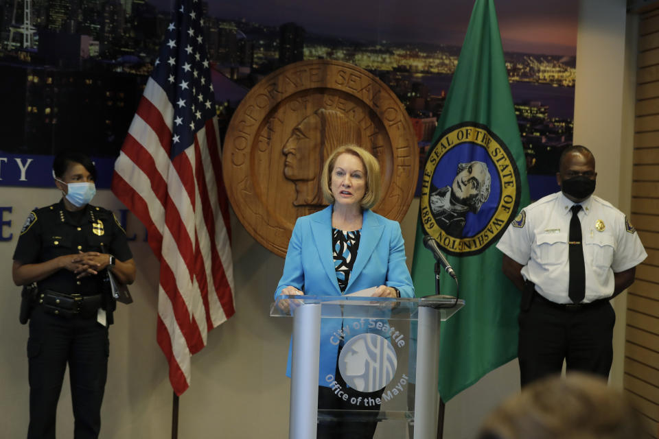 Seattle Mayor Jenny Durkan, center, speaks Monday, July 13, 2020, during a news conference at City Hall in Seattle as Police Chief Carmen Best, left, and Fire Chief Harold Scoggins , right, look on. Durkan and Best were critical of a plan backed by several city council members that seeks to cut the police department's budget by 50 percent. (AP Photo/Ted S. Warren)