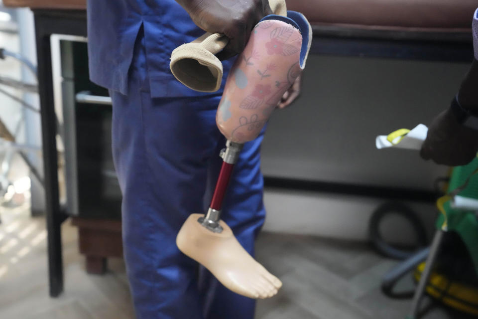 A prosthetist holds the artificial limb for Princess Igbinosa, 10, who lost her leg following a traffic accident in Lagos, Nigeria, Thursday, Nov. 1, 2023. Princess can now walk, thanks to an artificial limb from the IREDE Foundation, a group providing children like her with free prosthetics and helping their families offset the average cost of $2,000 to $3,000. (AP Photo/Sunday Alamba)