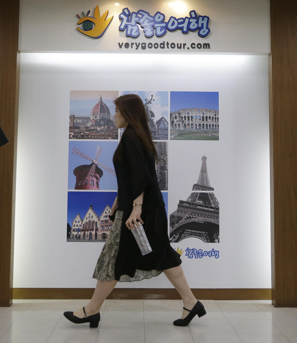A woman moves past a gate of the headquarters of Very Good Tour Co. in Seoul, South Korea, Thursday, May 30, 2019. A sightseeing boat carrying 33 South Korean passengers and two crew members collided with another vessel and sank in the Danube River in downtown Budapest. The South Korean tourists are confirmed to have been on a package tour to Hungary sold by the travel agency. (AP Photo/Ahn Young-joon)
