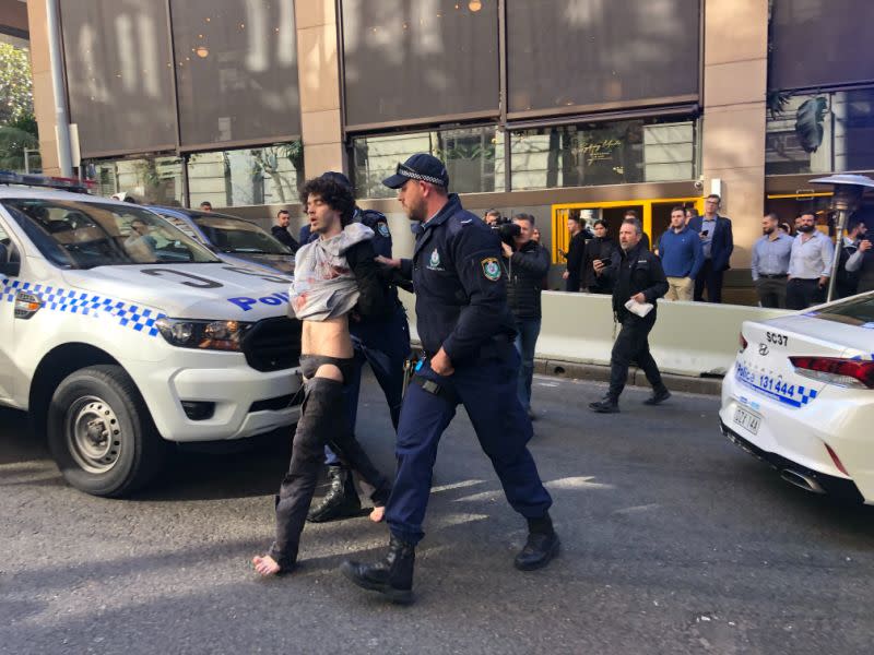 Sydney stabbing suspect Mert Ney is seen here being lead away by NSW Police officers in the CBD.