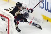 Boston Bruins' Jesper Boqvist (70) battles Washington Capitals' Joel Edmundson (6) for the puck during the first period of an NHL hockey game, Saturday, Feb. 10, 2024, in Boston. (AP Photo/Michael Dwyer)