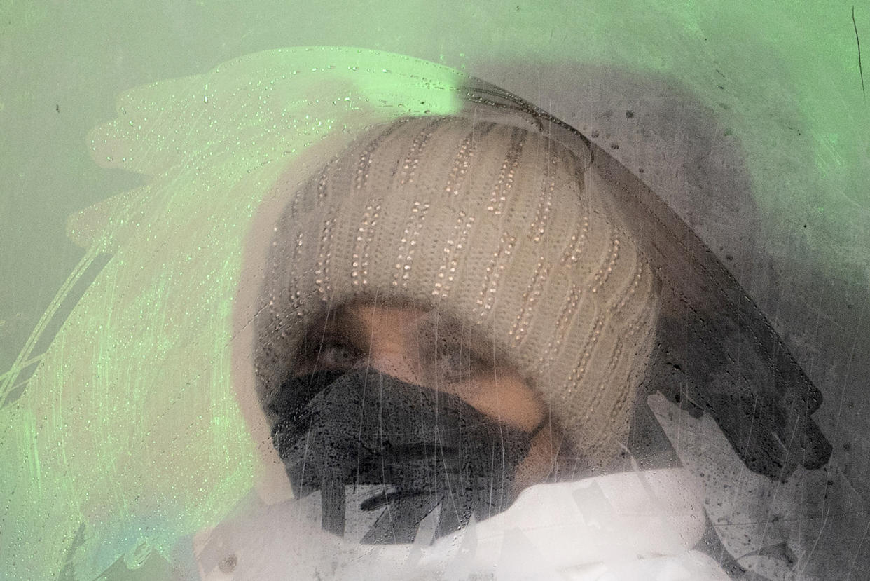 A woman wearing a face mask to help protect herself from the coronavirus looks from a fogged bus window in Ivano-Frankivsk, Western Ukraine, Friday, Jan. 8, 2021. The country of 42 million is recording about 9,000 new COVID-19 infections a day; more than 19,500 people have died. Ukraine imposes a wide-ranging lockdown beginning Friday, closing schools and entertainment venues and restaurant table service through Jan. 25. (AP Photo/Evgeniy Maloletka)